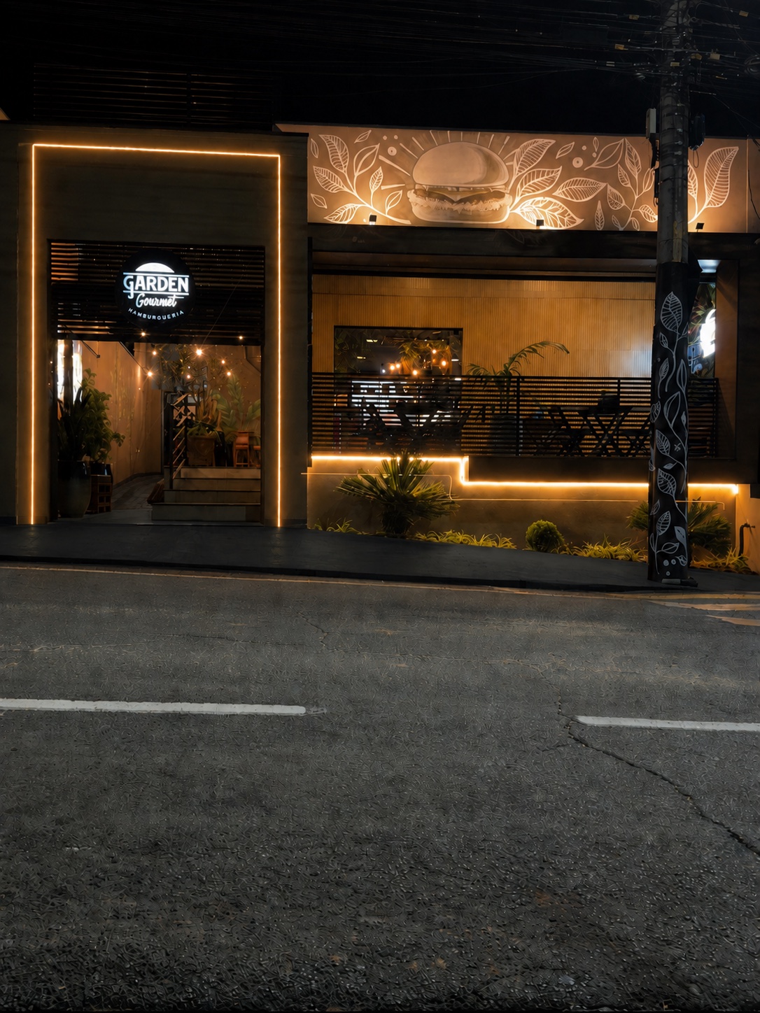 Fachada renovada do Garden Gourmet iluminada à noite